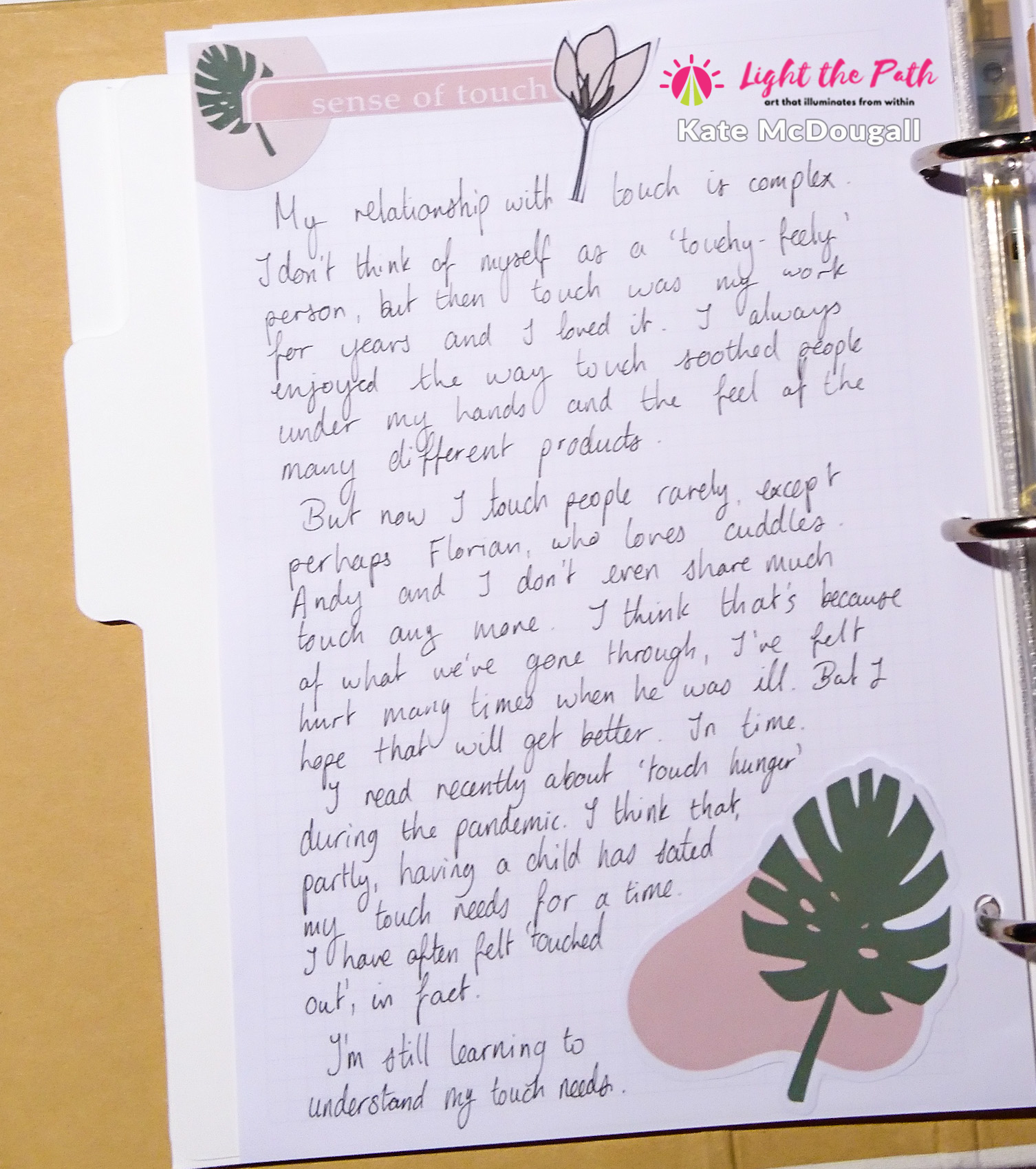 A page of journaling about the sense of touch. The page is embellished with pink and green elements featuring botanical illustrations.